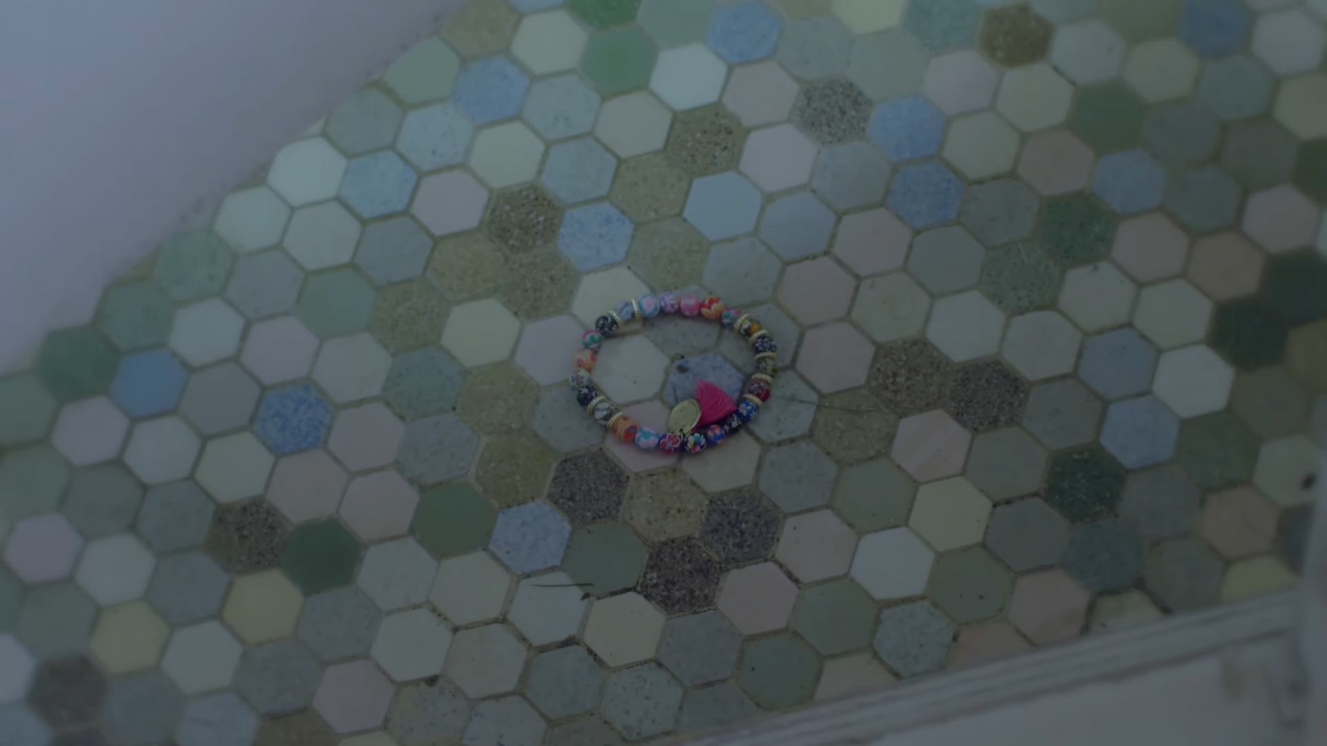 A colorful bead bracelet laying on the floor.